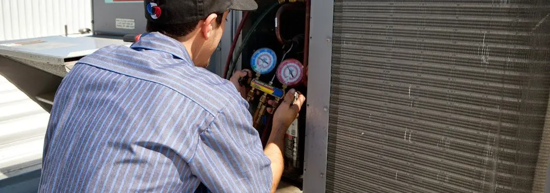 HVAC technician servicing a condenser unit in Maple Shade